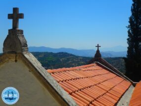 Ziegeldach einer traditionellen griechischen Kapelle mit Kreuzen vor einer malerischen Berglandschaft auf Kreta, ideal für E4-Wanderungen und Ausflüge ins unbekannte Kreta.