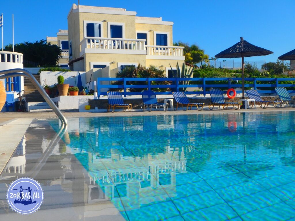 Spiegelung der Zorbas Island Ferienwohnungen im Poolwasser unter blauem Himmel in Kokkini Hani, Kreta.