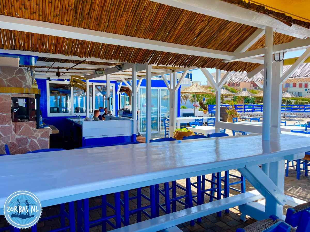 De wit-blauwe kleuren op Zorbas Island (Kokkini Hani, Kreta) weerspiegelen de ultieme Griekse sfeer, met wit voor puurheid/koelte en blauw voor de zee en lucht. Deze combinatie, die ook de Griekse vlag siert, trekt toeristen en is historisch gegroeid vanuit hygiënische redenen (witkalk) en nationale branding tijdens de junta